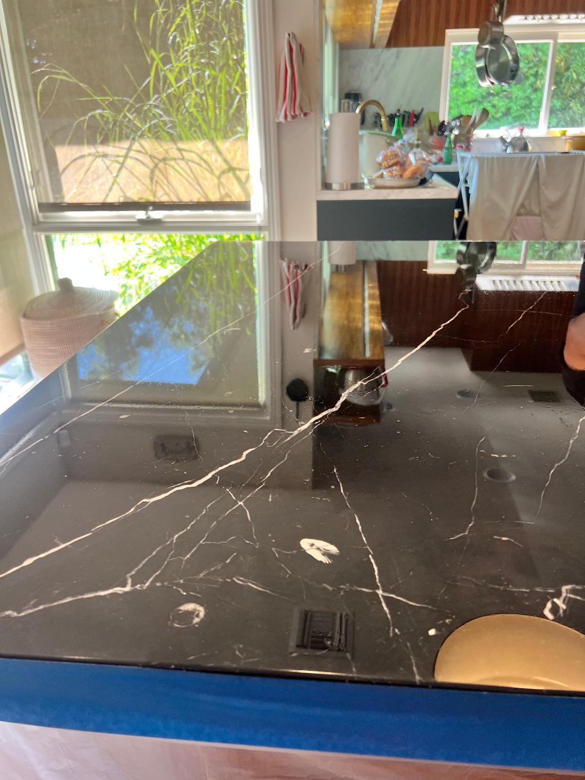Black marble kitchen island countertop with restored reflective finish