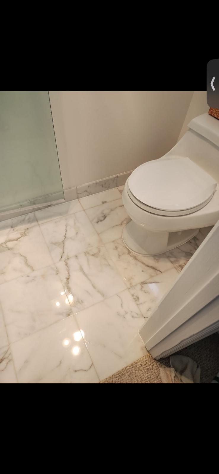 White marble bathroom floor with a restored reflective finish