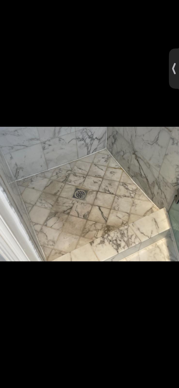 Marble shower floor with built-up dirt and soap residue