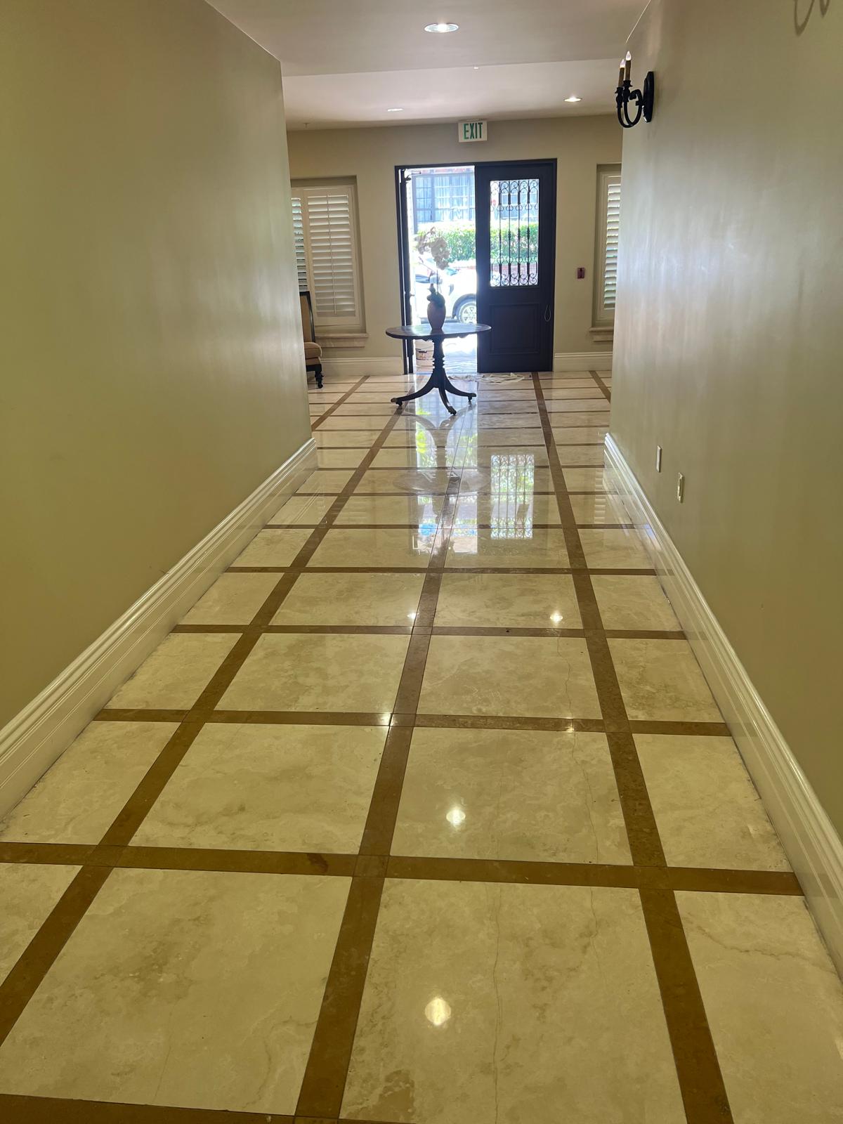 Reflective stone floor near a hallway prepared for sealing