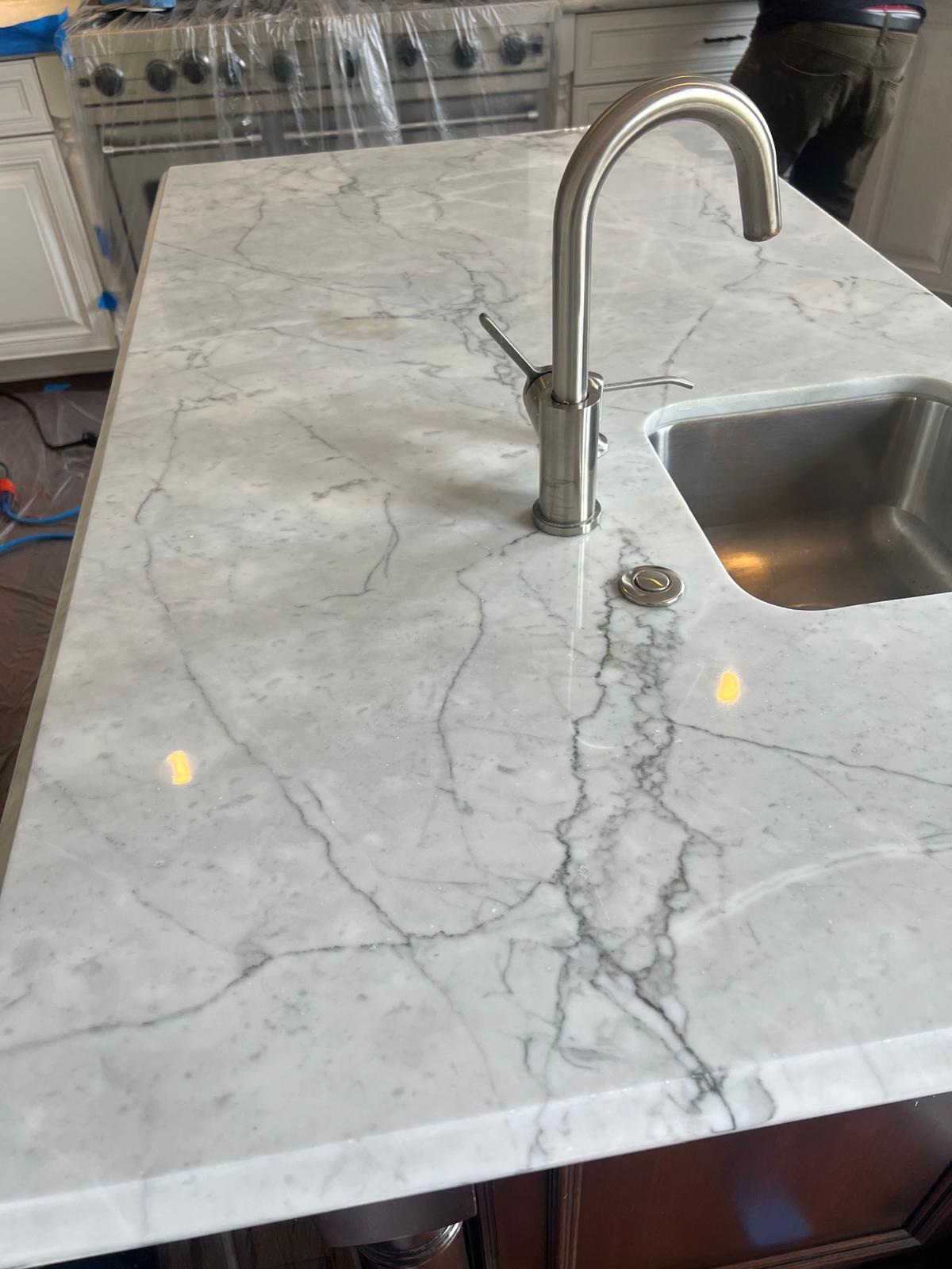White marble kitchen island prepared for a professional restoration assessment