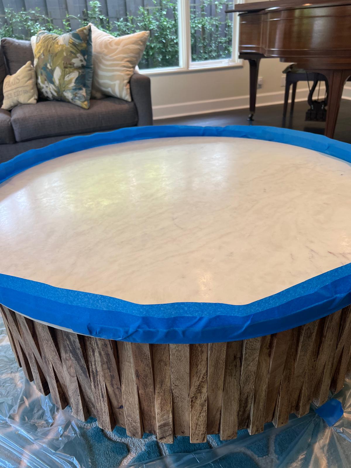 Marble tabletop taped and prepared for protective sealing