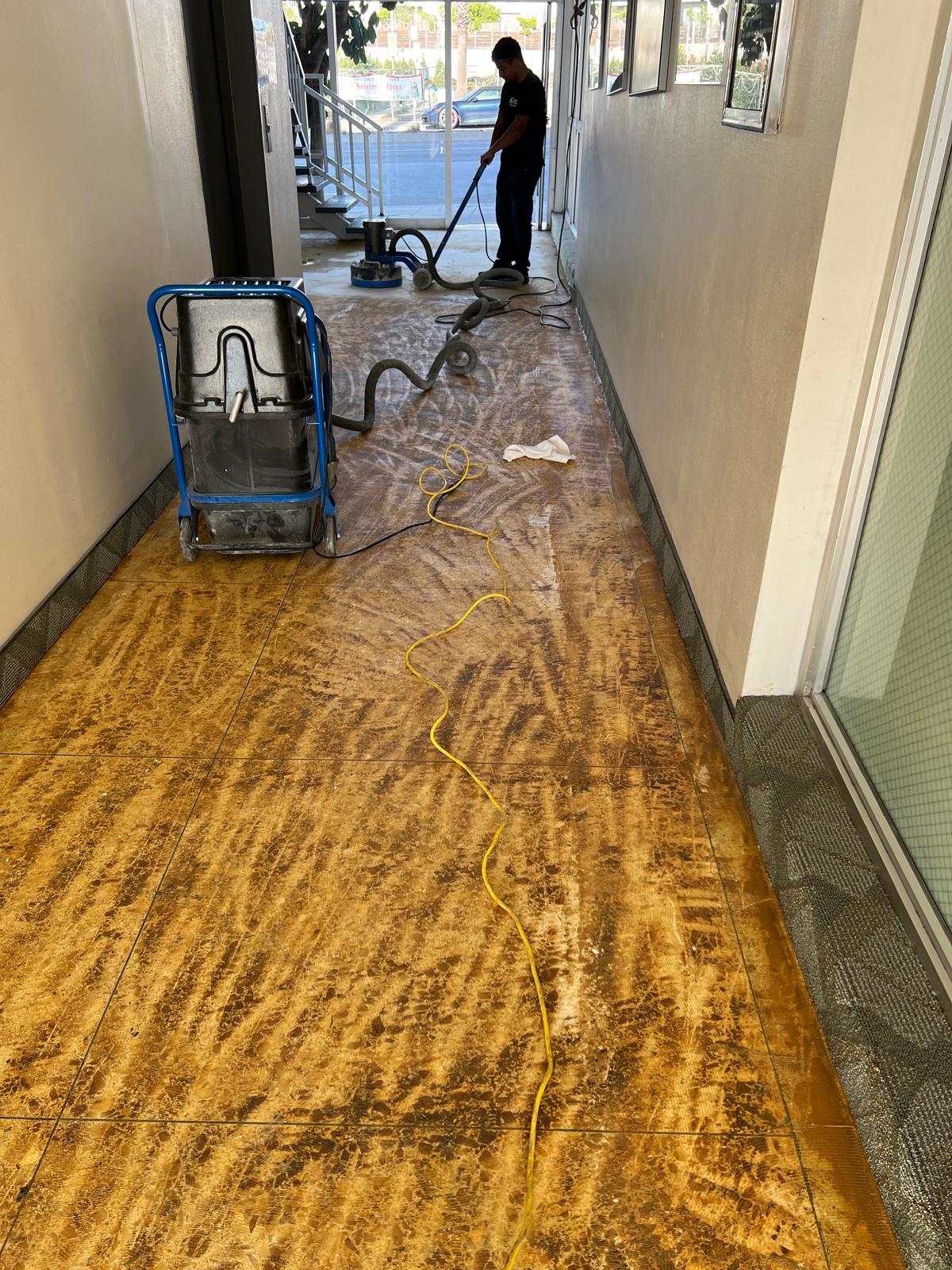 Technician stripping an old coating from a tile floor