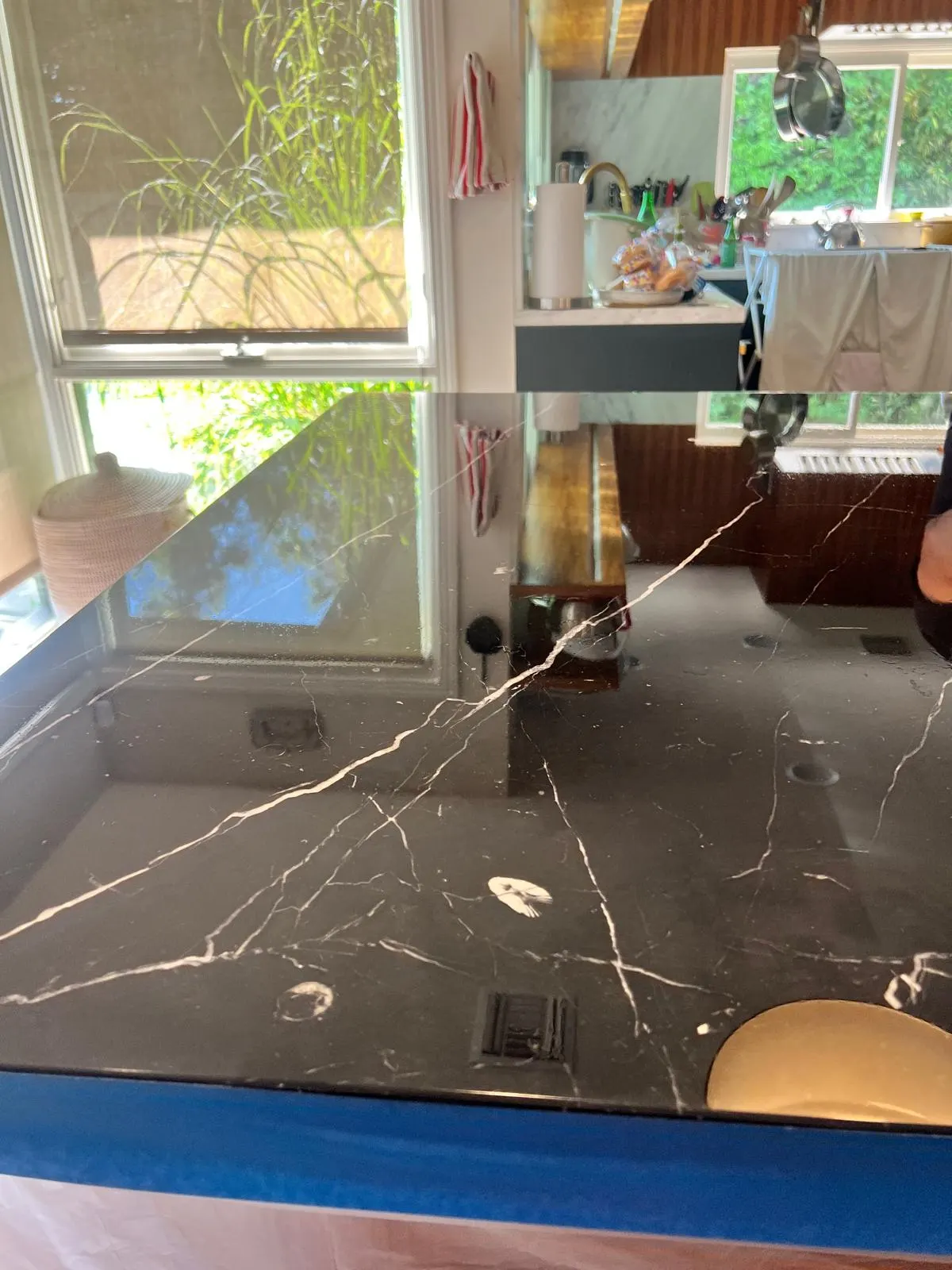 Black marble kitchen island countertop with restored reflective finish