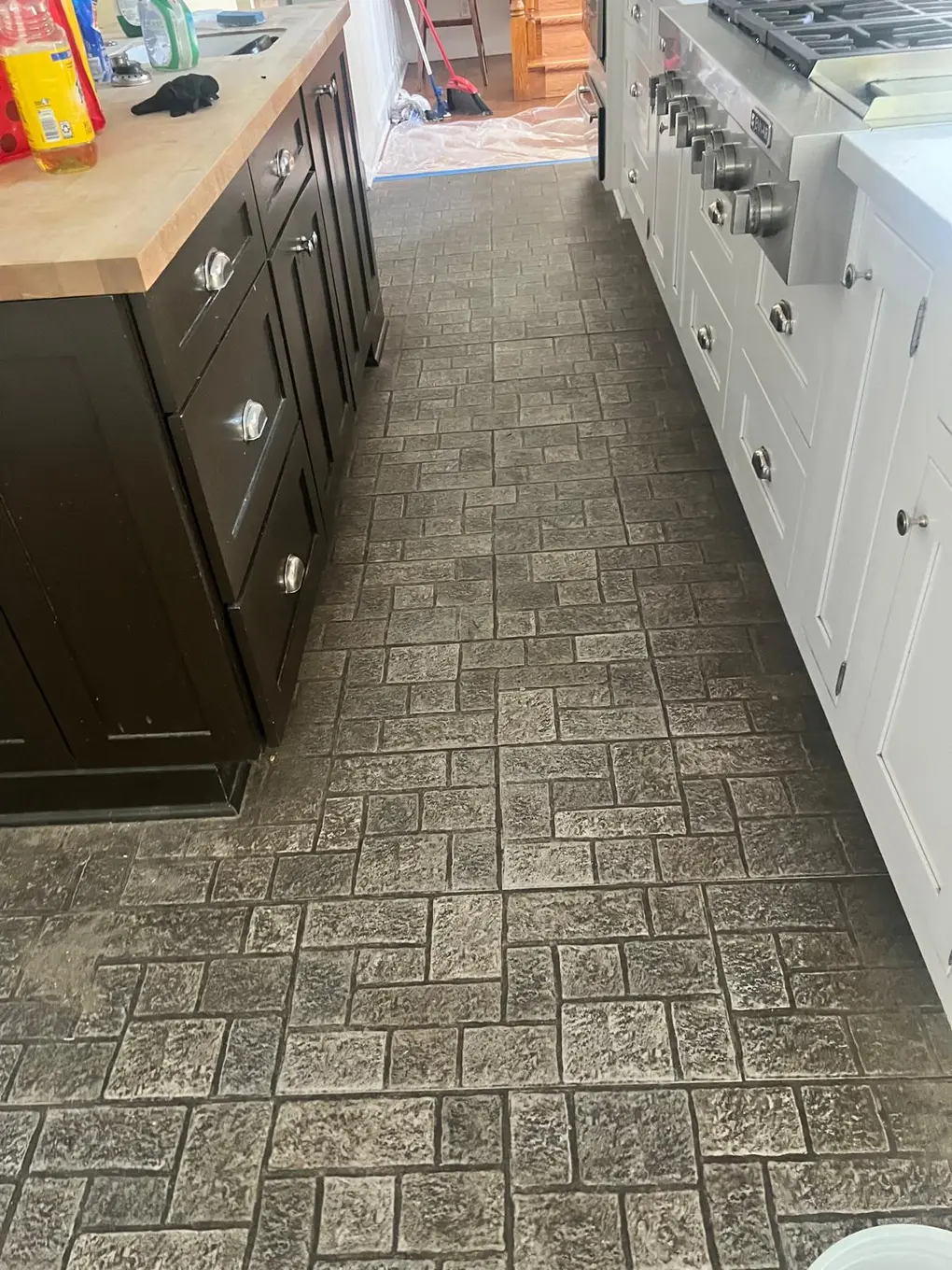 Textured stone kitchen floor with embedded dirt before cleaning