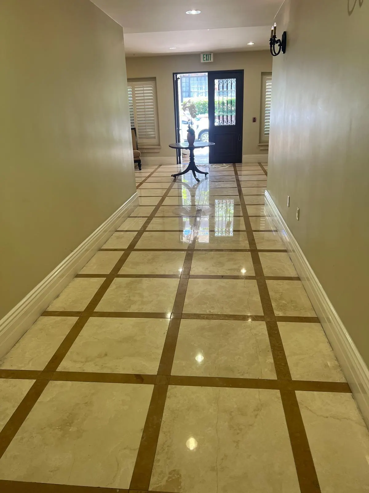 Reflective stone floor near a hallway prepared for sealing