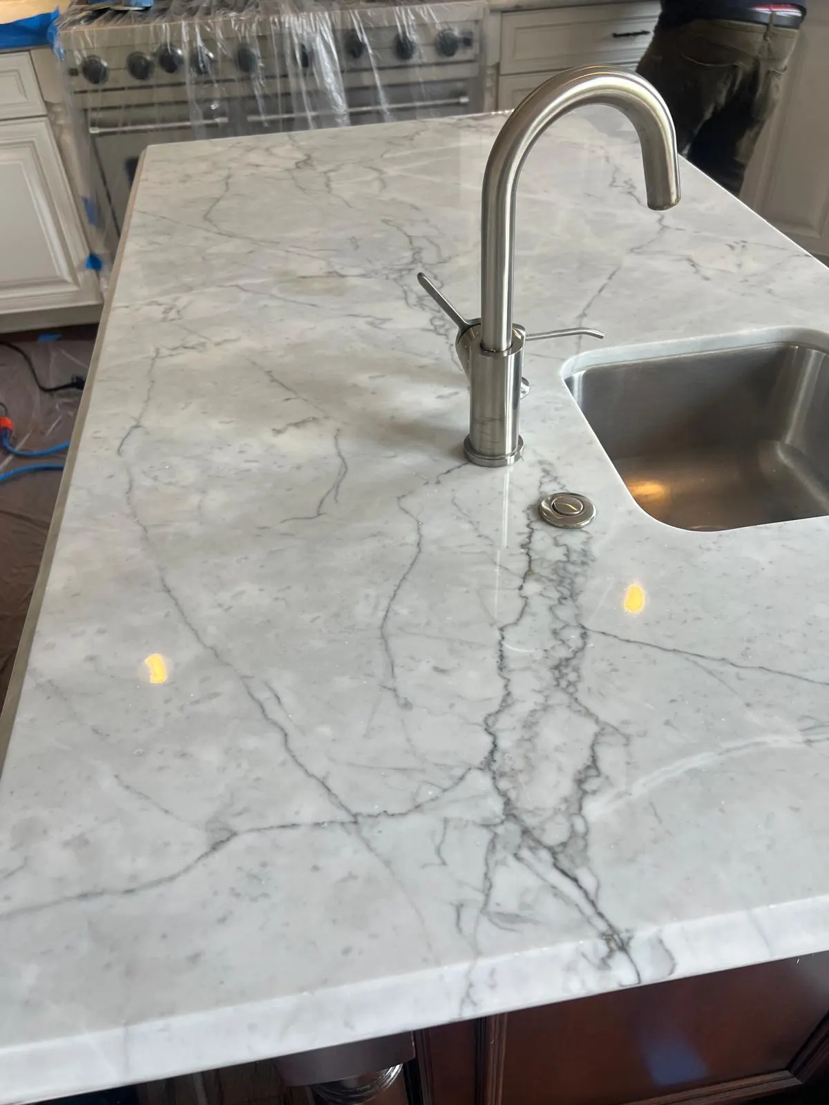 White marble kitchen island prepared for a professional restoration assessment