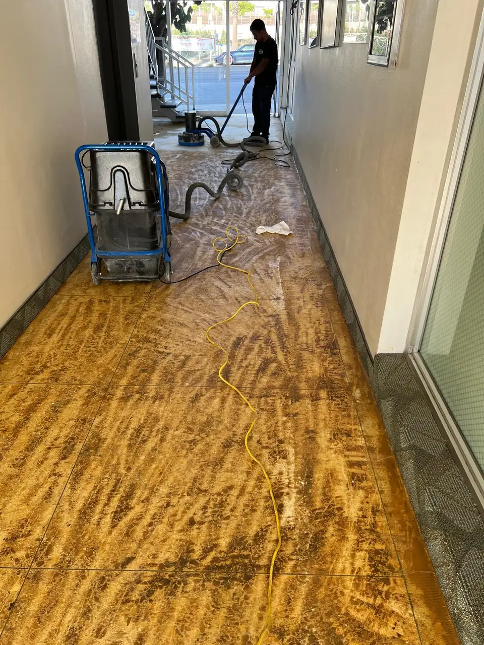 Technician stripping an old coating from a tile floor