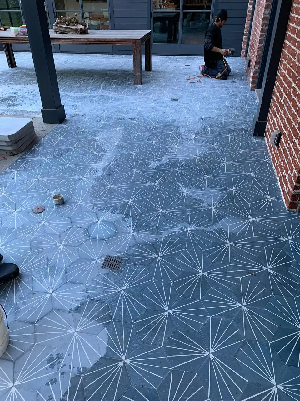 Technician honing patterned outdoor patio tiles with water